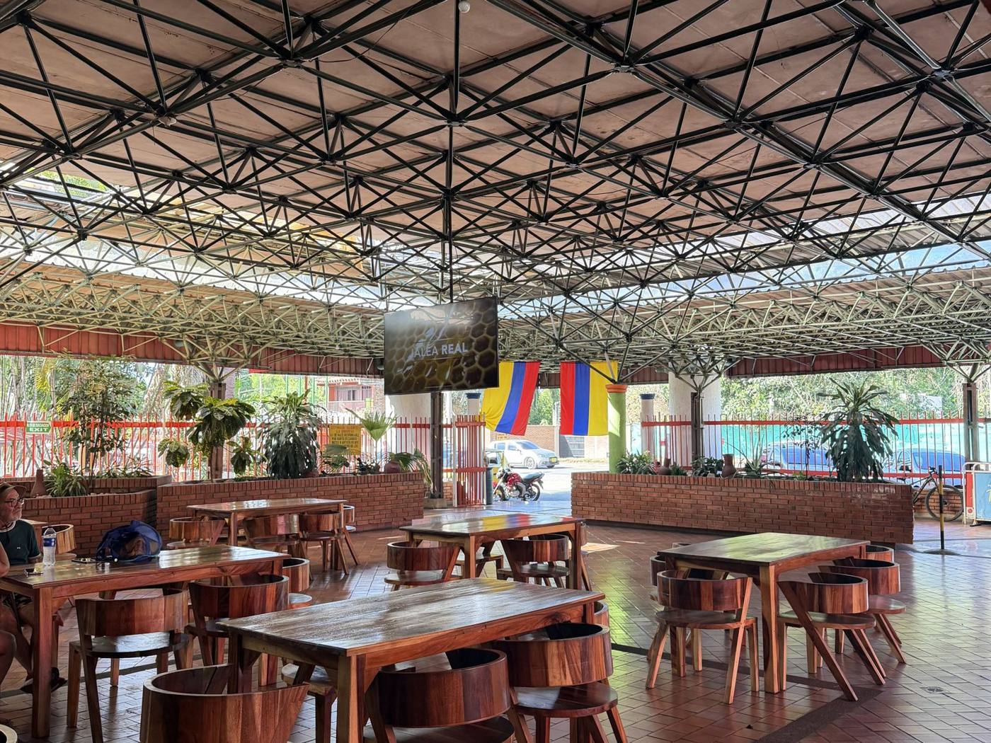 Mesas de madera del restaurante con vista a los jardines de Las Pirámides